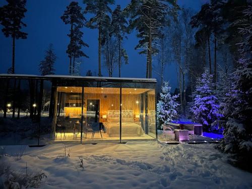 Murjāņi7Mirrors的夜晚雪中的一个玻璃屋