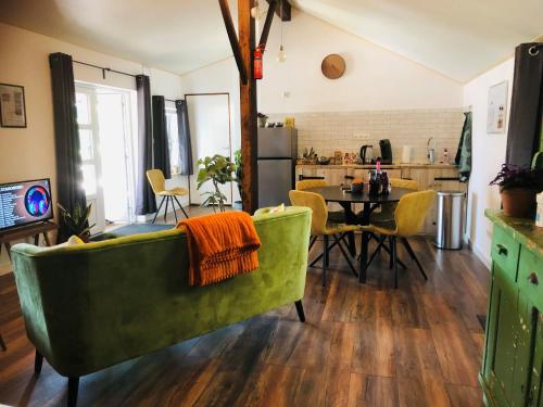 MaasbreeB &B Yuupke Maasbree Noord-Limburg Venlo Roermond的客厅配有绿色沙发和桌子