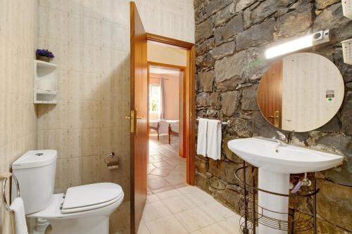 JunqueiraCasa Cristina的浴室配有卫生间水槽和石墙。