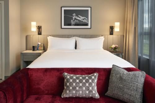 雷德蒙德Archer Hotel Seattle/Redmond的一间卧室配有一张大床和红色沙发