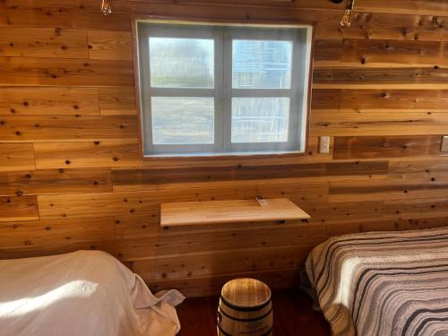 益城町Glamping Village LEAF的卧室设有木墙窗户