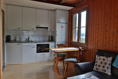 穆尔滕Hof Oberprehl的厨房配有白色橱柜和桌椅