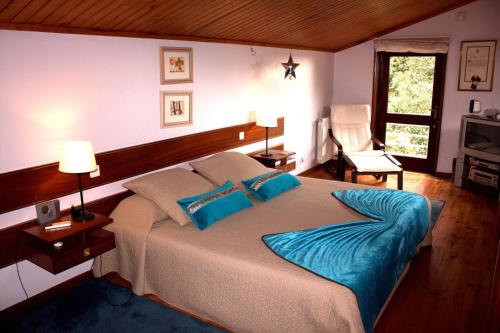贡多马尔Cork Tree Villa的一间卧室配有一张带蓝色枕头的大床