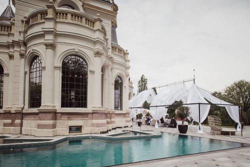TuraBOTANIQ Castle of Tura - Small Luxury Hotels of the World的一座大型建筑,前面设有一个游泳池