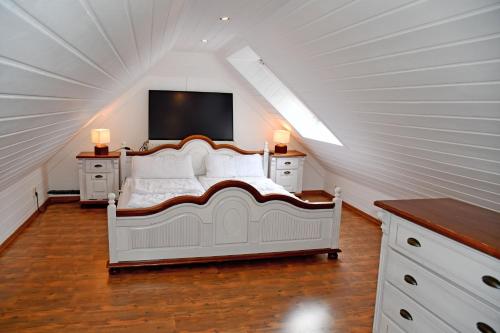 卑尔根Reetdachfachwerkvilla am Wiesengrund的阁楼卧室配有白色床