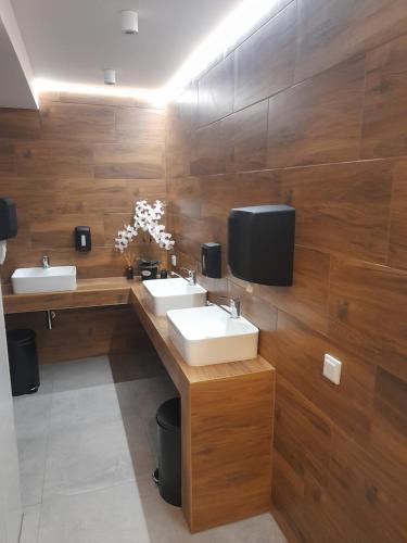 乌斯特龙SCHRONISKO GOŚCINIEC RÓWNICA的一间带两个盥洗盆的浴室和墙上的电视