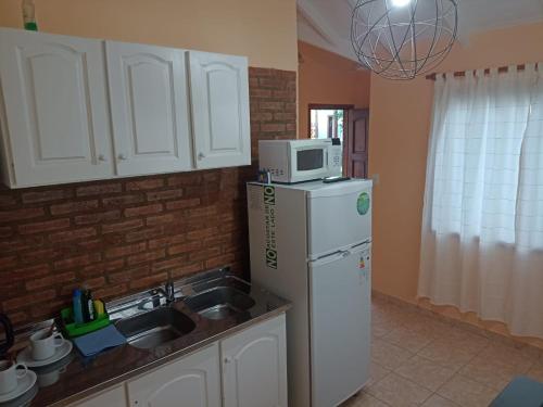 埃尔卡拉法特UAKEN CABAÑAS的厨房配有白色冰箱和微波炉