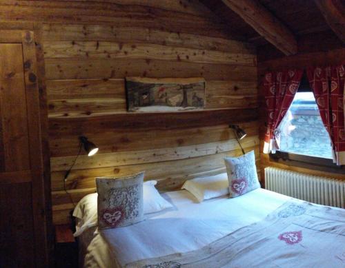 瓦托内切BAITA Ancienne Bergerie的卧室配有木墙内的一张床