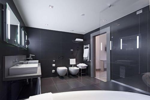 帕尔马帕尔马NH酒店的黑色浴室设有两个卫生间和水槽