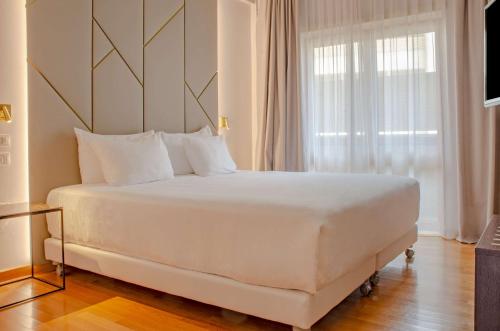 罗马罗马查士丁尼NH系列酒店的窗户客房内的一张大白色床