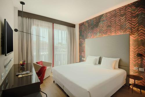米兰米兰普雷西登特NH精选酒店的酒店客房设有白色的床和窗户。