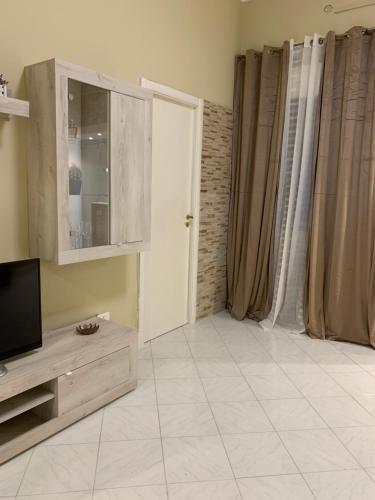巴勒莫Casa Leila的带电视的客厅和瓷砖地板。