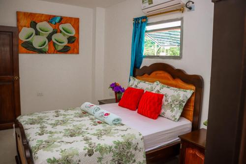 帕洛米诺Hotel Flor Gloria的小卧室配有红色枕头的床