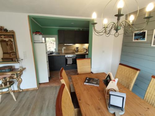 温特贝格adBs Ferienhaus的厨房以及带木桌和椅子的用餐室。