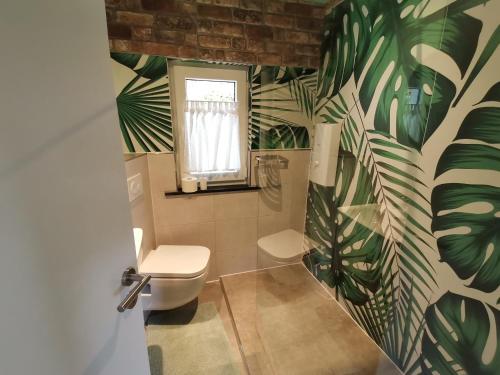 温特贝格adBs Ferienhaus的浴室设有卫生间,墙上绿叶环绕。