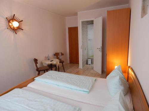 蒙绍哈格尔鲁酒店的一间卧室配有一张床铺和一张桌子,另一间卧室配有一张桌子。