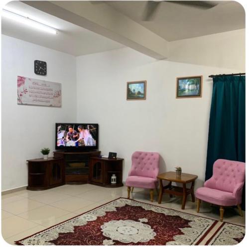 居銮Sobey Laris Homestay MAS AYU的客厅配有2把粉红色的椅子和电视