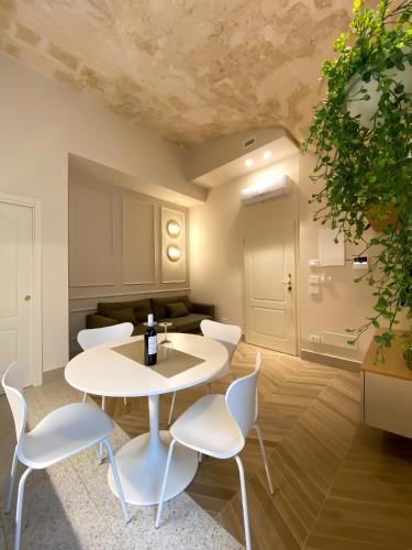莫诺波利Dimore Garibaldi - Puglia Mia Apartments的客厅配有桌子和白色椅子