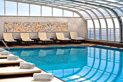 塞辛布拉SANA塞新布拉酒店的一座带椅子和绘画的游泳池