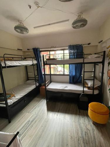 孟买Krazy Solo Hostel的客房设有三张双层床,铺有木地板。