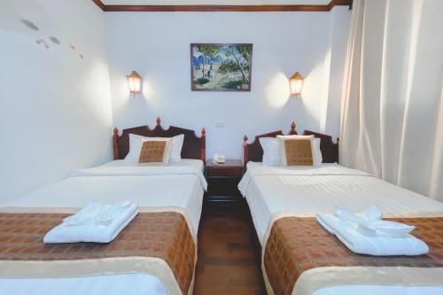 Ban NongdouangKhampiane1 Hotel的客房设有2张床,配有白色的床单和毛巾。