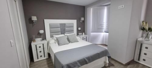 拜纳Virrey del Pino - Apartamento en Baena的一间白色卧室,配有床和2个床头柜