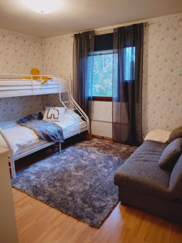 库萨莫Ruka Kierävä with ski tickets的一间带两张双层床和一张沙发的卧室