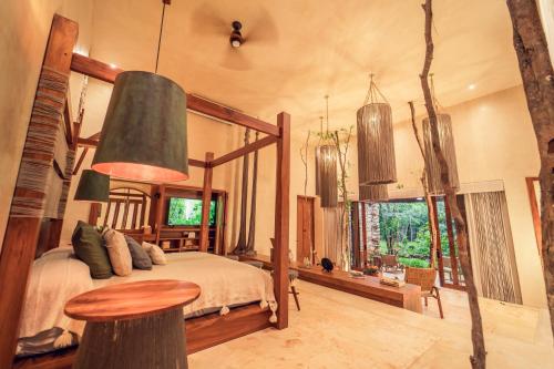 巴利亚多利德Oriundo Luxury Nature Villas的一间卧室配有一张床、一张桌子和一些窗户