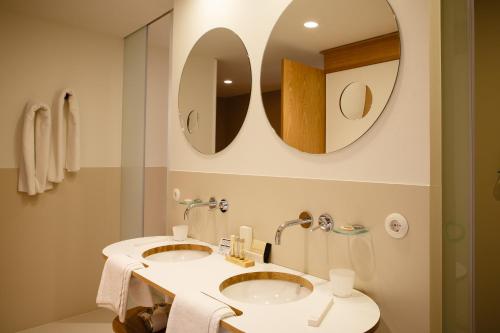 仕格莱伊卡伦美食酒店的浴室设有2个水槽和2面镜子