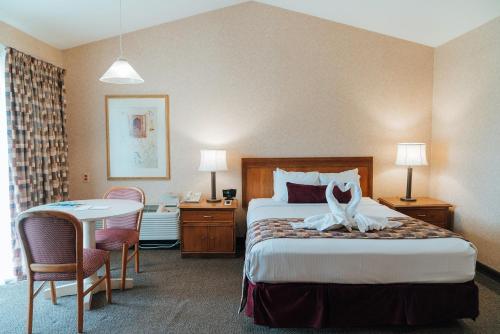 斯卡尼阿特勒斯Skaneateles Suites的酒店客房配有一张床铺和一张桌子。