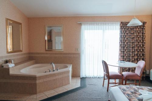 斯卡尼阿特勒斯Skaneateles Suites的带浴缸和桌椅的浴室