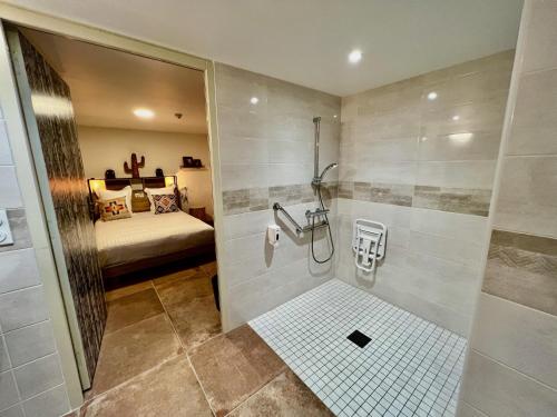 布吕隆Hotel Le Ranch的带淋浴的浴室和客房内的一张床