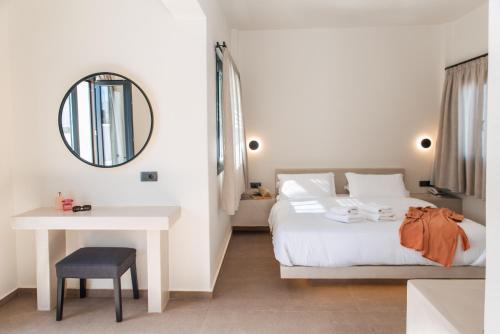 伊亚North Wind Luxury Suites的一间卧室配有一张床、一张桌子和一面镜子
