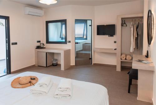 伊亚North Wind Luxury Suites的酒店客房设有白色的床和浴室。