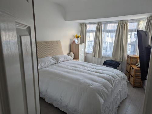 埃德蒙顿Spacious 2 bedroom house with garden的卧室配有白色的床和窗户。