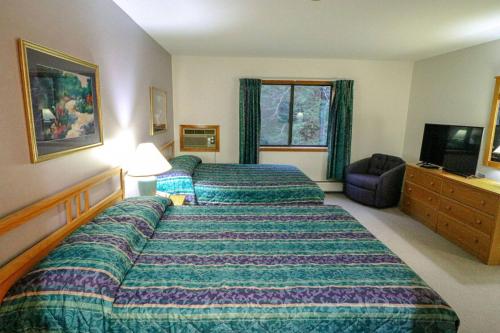 基灵顿Cedarbrook Two Double bed Standard Hotel room 118的酒店客房设有两张床和电视。