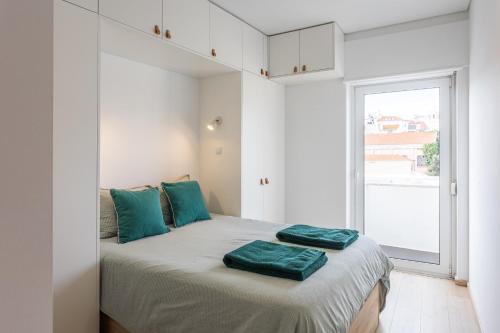 里斯本Tejo River View Apartment nearby Belém的一间卧室配有一张带绿色枕头的床。