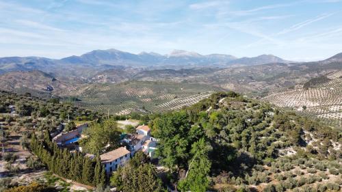 CarchelejoEL CONVENTO Vivienda Rural Jaén Andalucía España的享有山脉葡萄园的空中景致