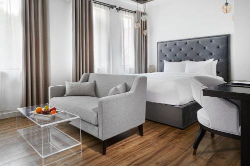 卡利登Mount Alverno Luxury Resorts的一间卧室配有一张床、一张沙发和一把椅子