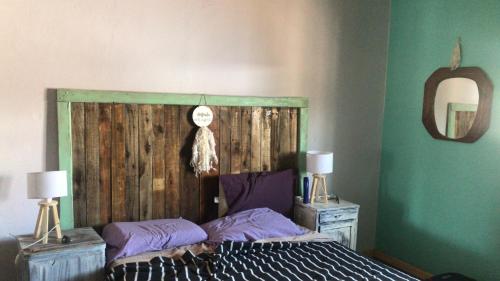 圣卡洛斯Los Chañares的一间卧室配有一张带木制床头板的床