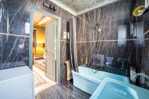 巴黎Place Vendôme Luxe 60 SQM Bail mobilité的浴室配有蓝色浴缸和水槽