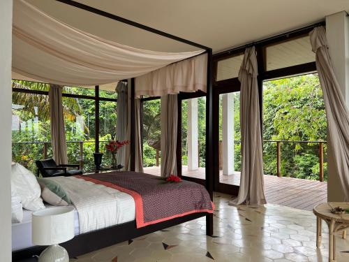 Santo AntónioVilla Principe的一间卧室配有一张带天蓬和大窗户的床