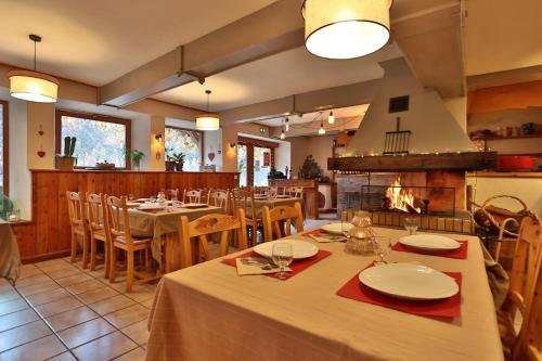 弗雷斯涅Hôtel Restaurant Gîtes Les 5 Saisons的一间带桌椅和壁炉的用餐室