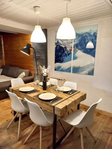 圣热尔韦莱班Bel appartement familial et cosy的一间带木桌和白色椅子的用餐室