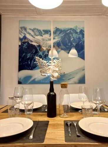 圣热尔韦莱班Bel appartement familial et cosy的一张木桌,配有一瓶葡萄酒和玻璃杯