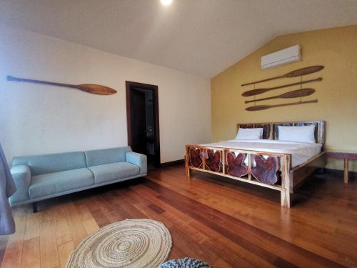 Pueblo NuevoGatun Lake Lodge Hotel的一间卧室配有一张床和一张沙发