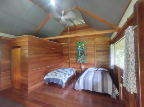 马尔多纳多港Quirquincho House的木墙客房的两张床