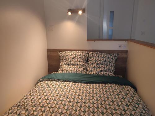 南希Le Champêtre的小卧室配有一张带床头板的床