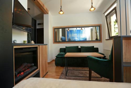 亚霍里纳Apartman KUTAK Jahorina的客厅设有绿色沙发和壁炉