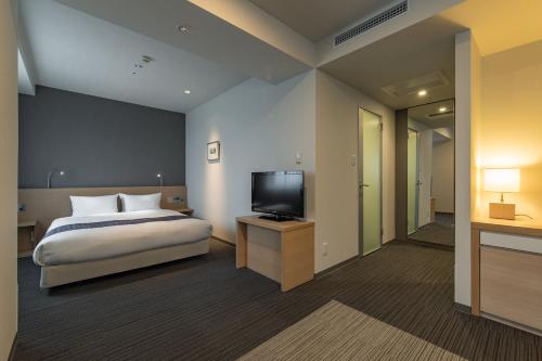 宫崎JR九州宫崎酒店的一间卧室配有一张床和一台平面电视